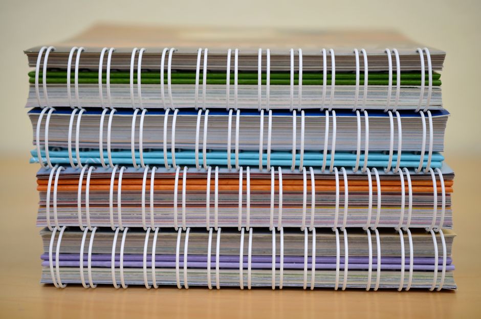 Different notebooks stacked on desk