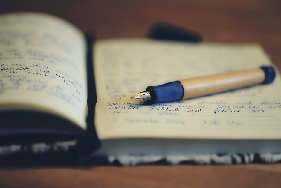 Fountain pen resting on an open notebook filled with handwriting